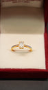 Gold ring with a diamond in a red jewelry box