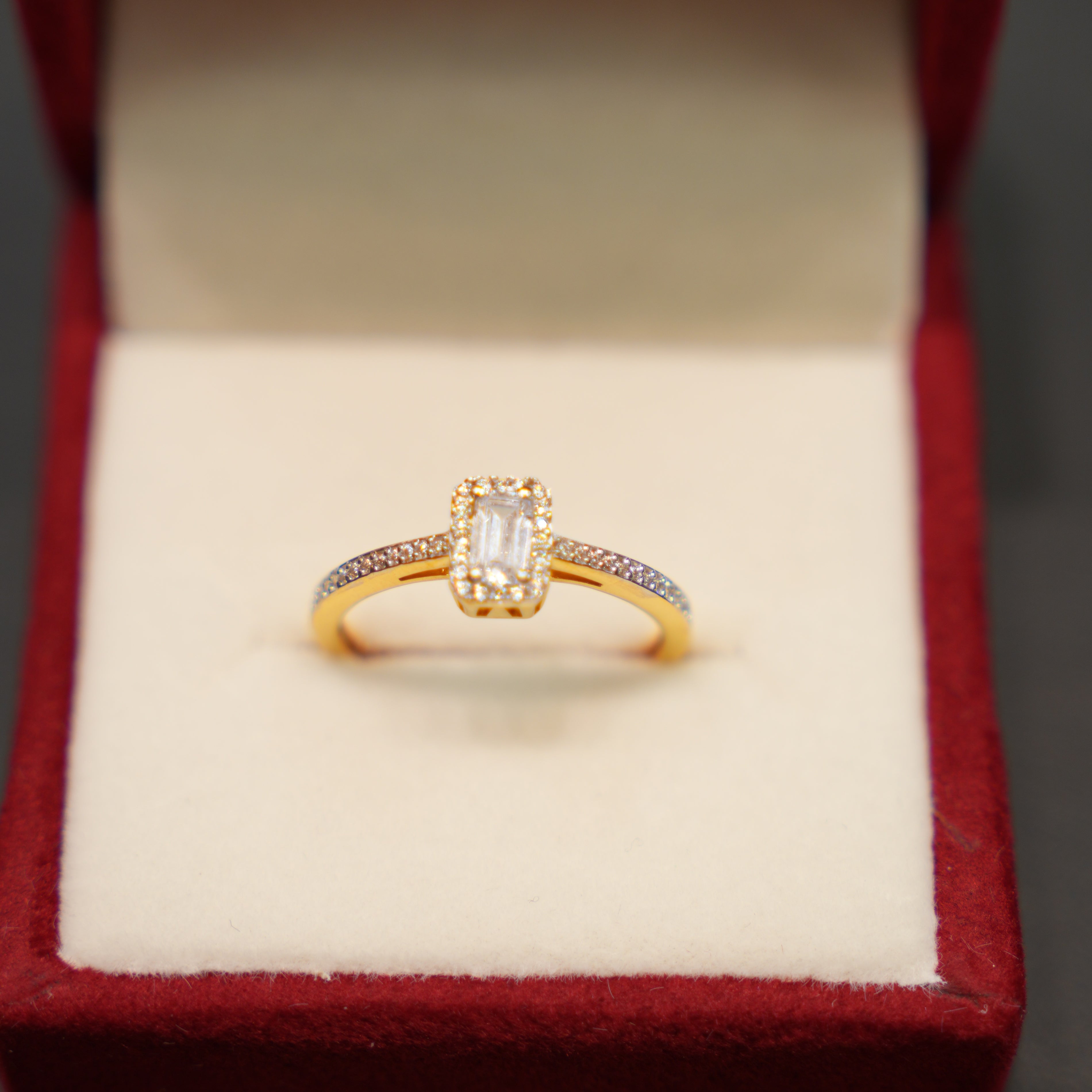 Gold ring with a diamond in a red jewelry box