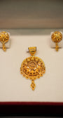 Gold pendant and earrings set on a white background