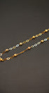 Gold and silver chain necklace on a dark gray background