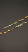 Gold and silver chain necklace on a dark gray background