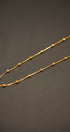 Gold chain necklace on a dark gray background