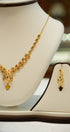Gold necklace and earrings on a mannequin bust with a blurred background