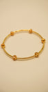 Gold bracelet on a beige background