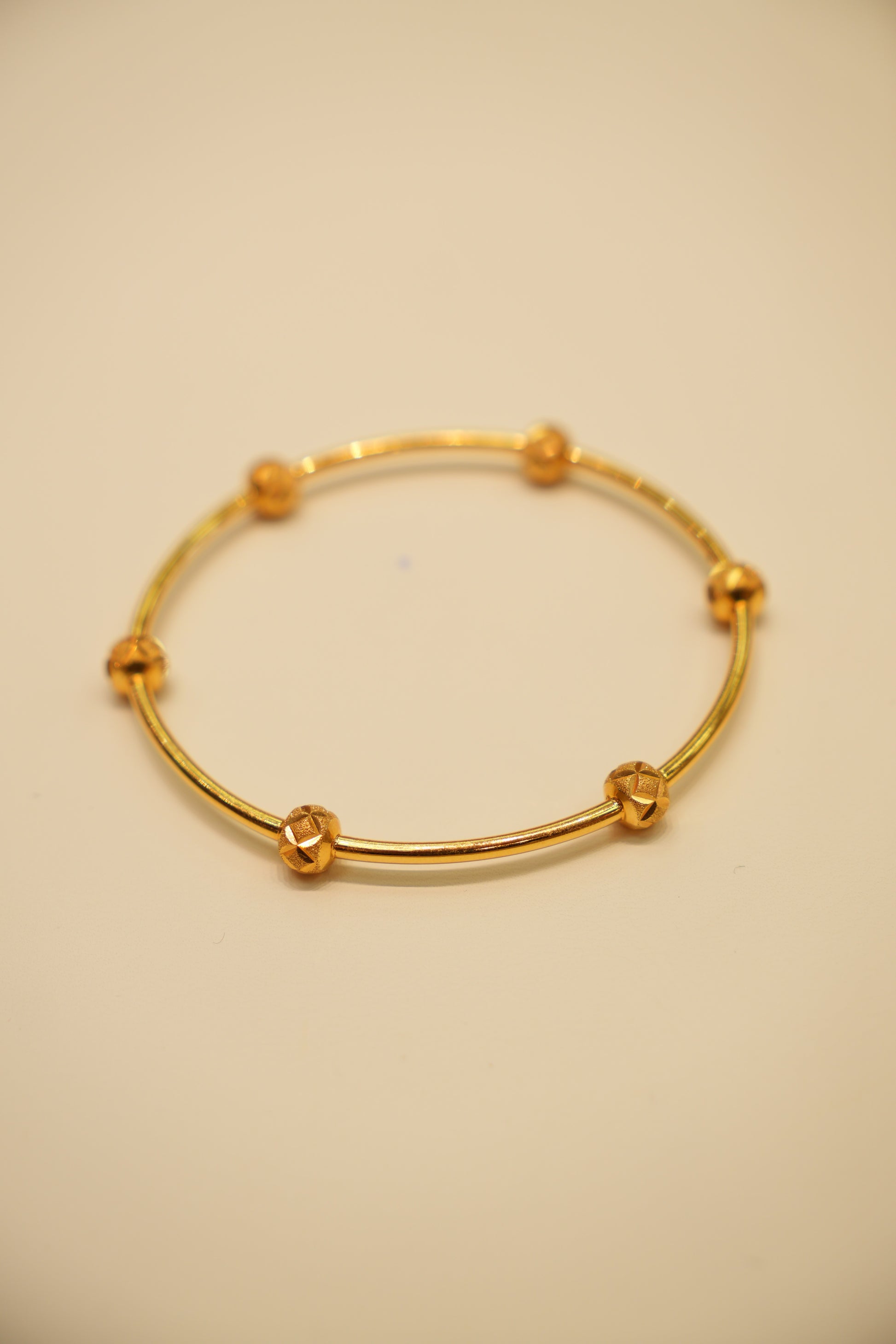 Gold bracelet on a beige background