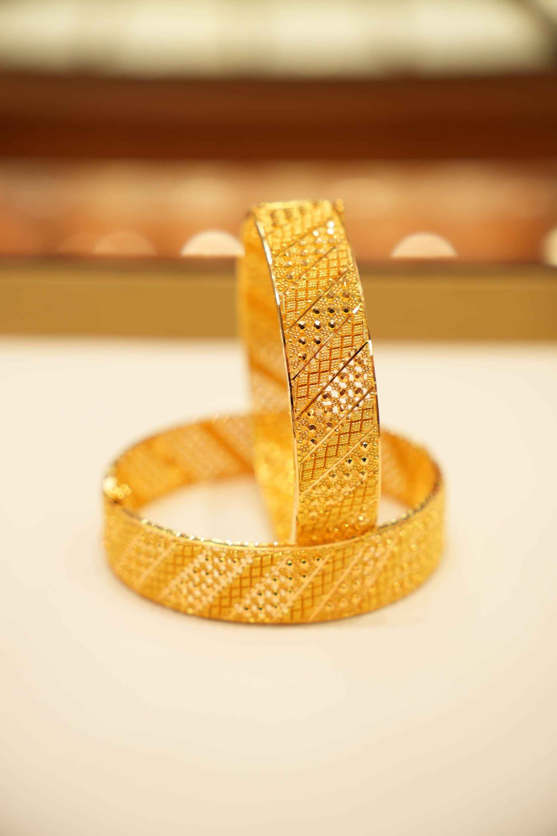 Gold bracelet with textured design on a light background