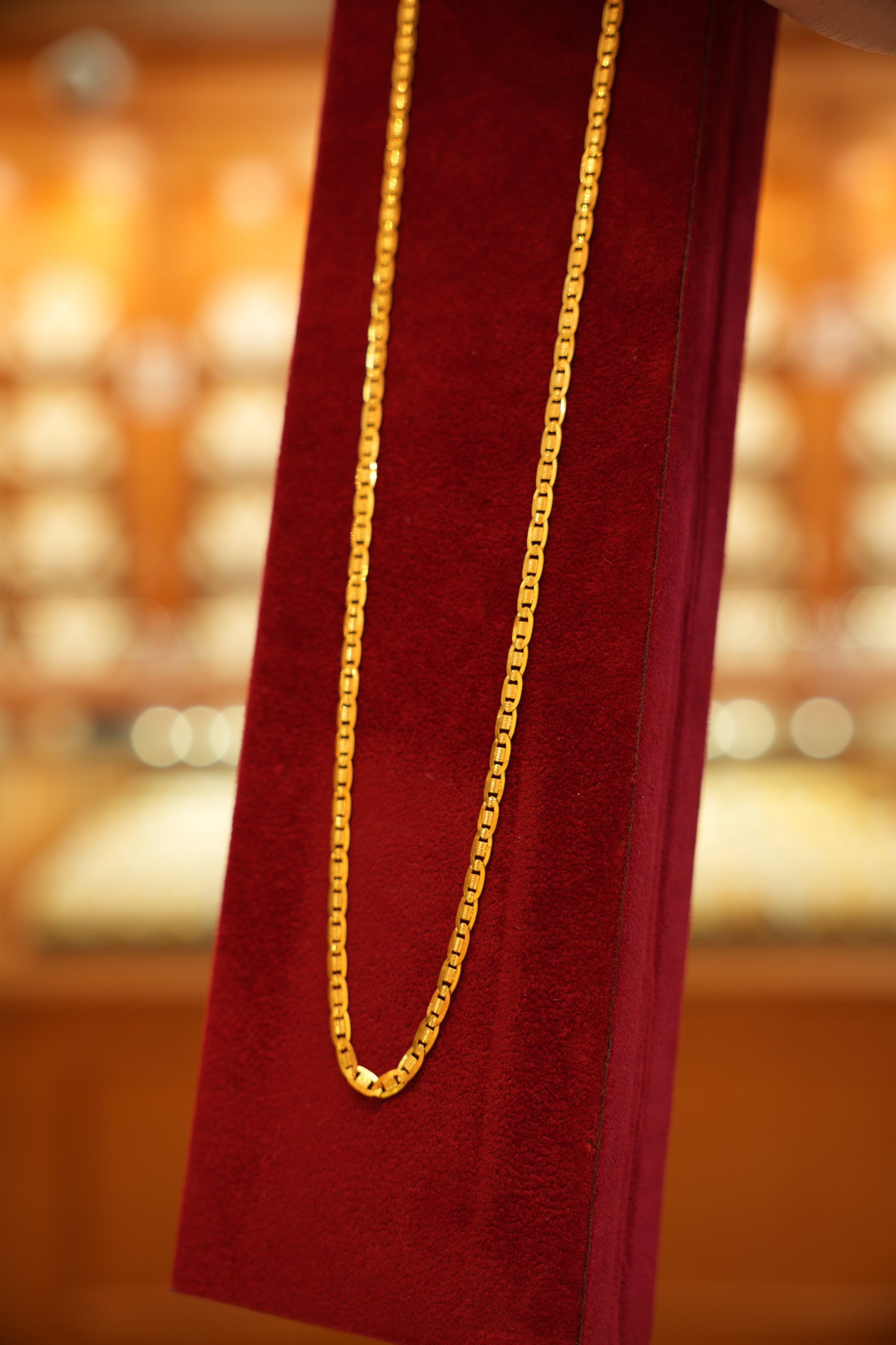 Gold chain on a red fabric with a blurred background