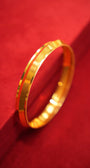 Gold bracelet on a red textured surface
