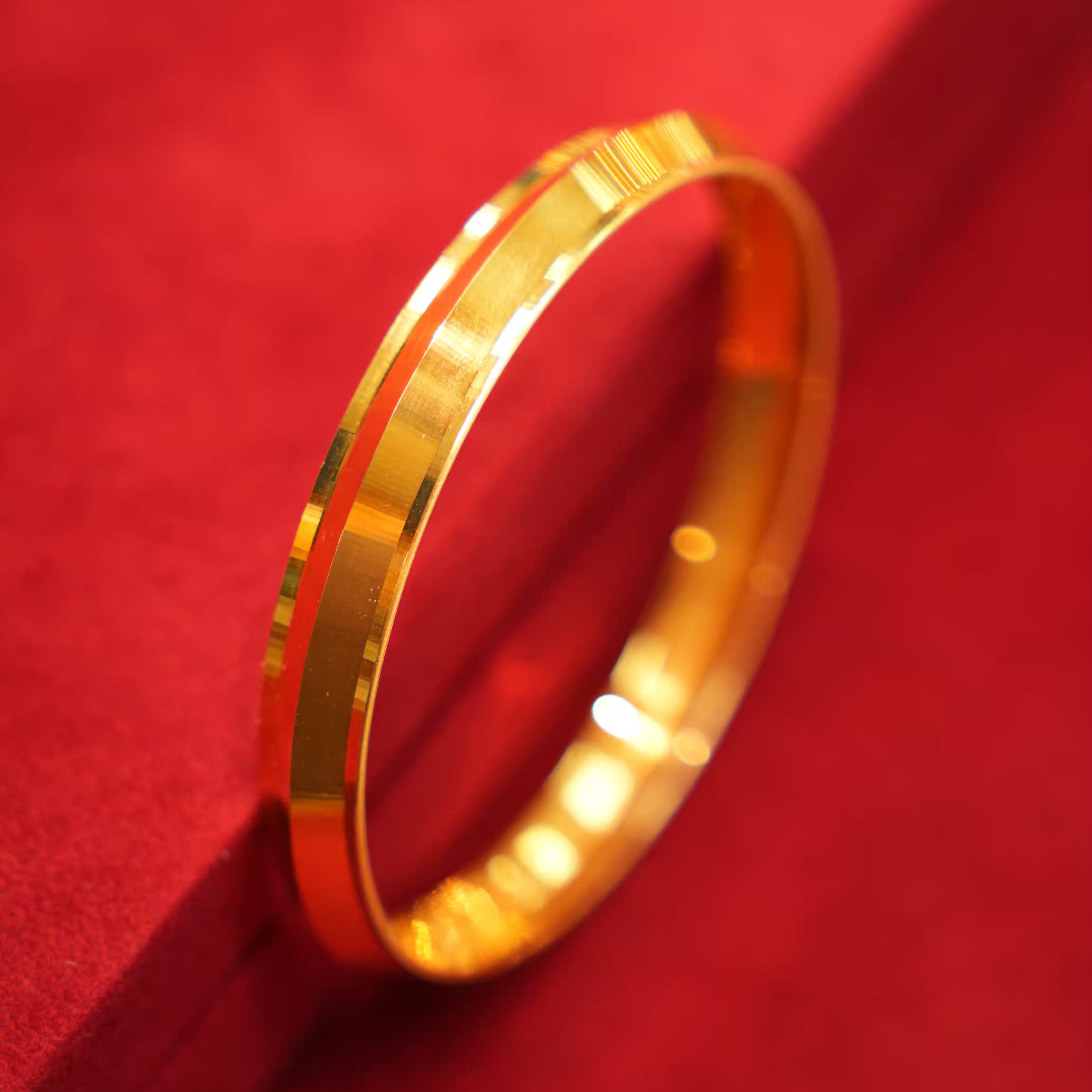 Gold bracelet on a red textured surface