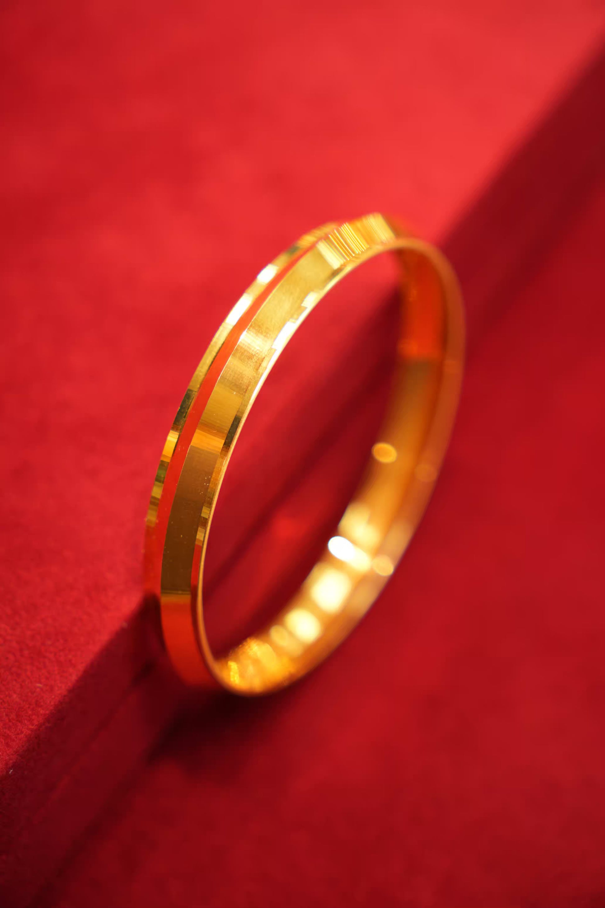 Gold bracelet on a red textured surface