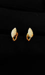 Pair of gold earrings with clear gemstones on a black background