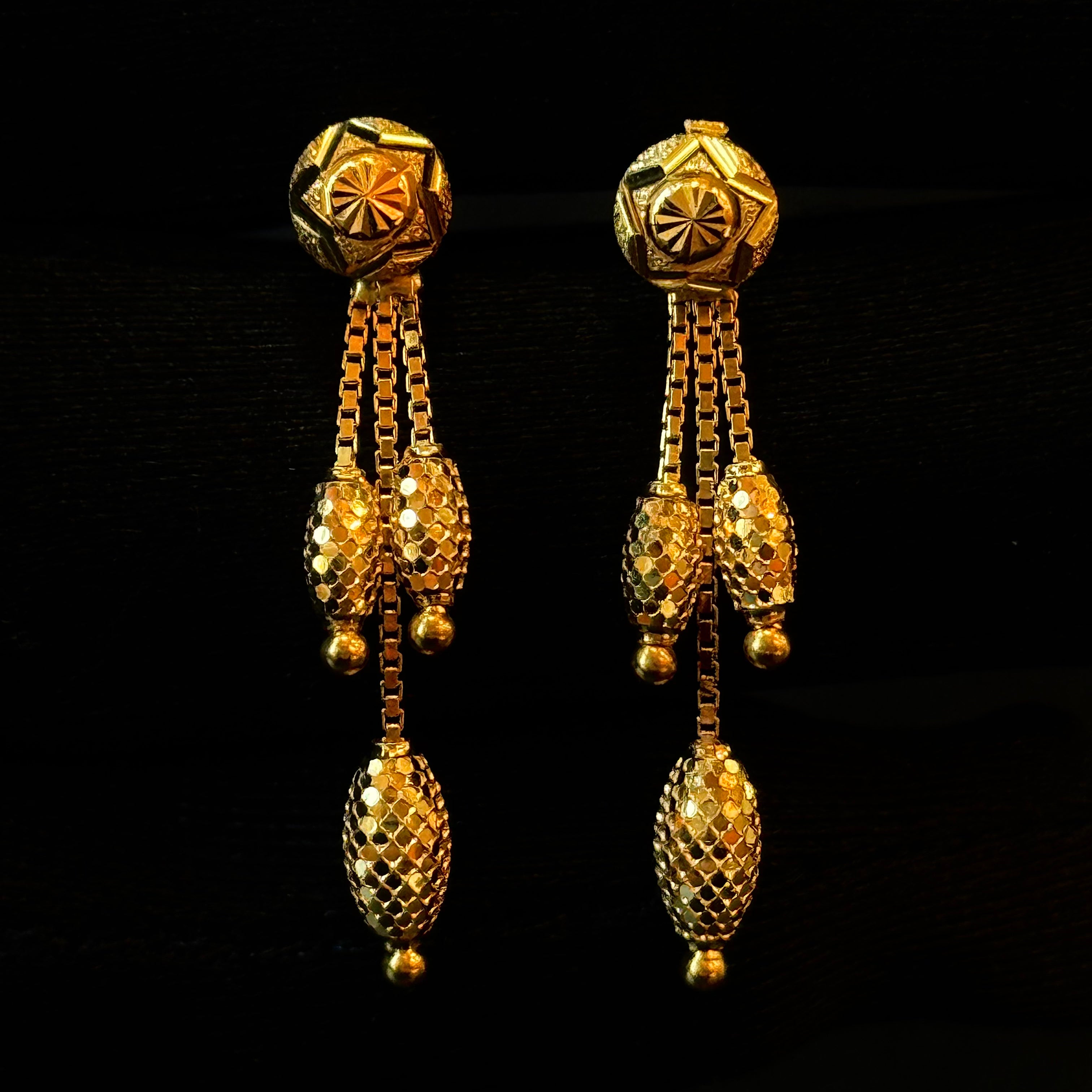 Pair of gold earrings on a black background