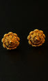 Pair of gold floral earrings on a black background