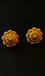Pair of gold floral earrings on a black background