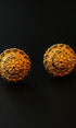Pair of gold earrings on a black background