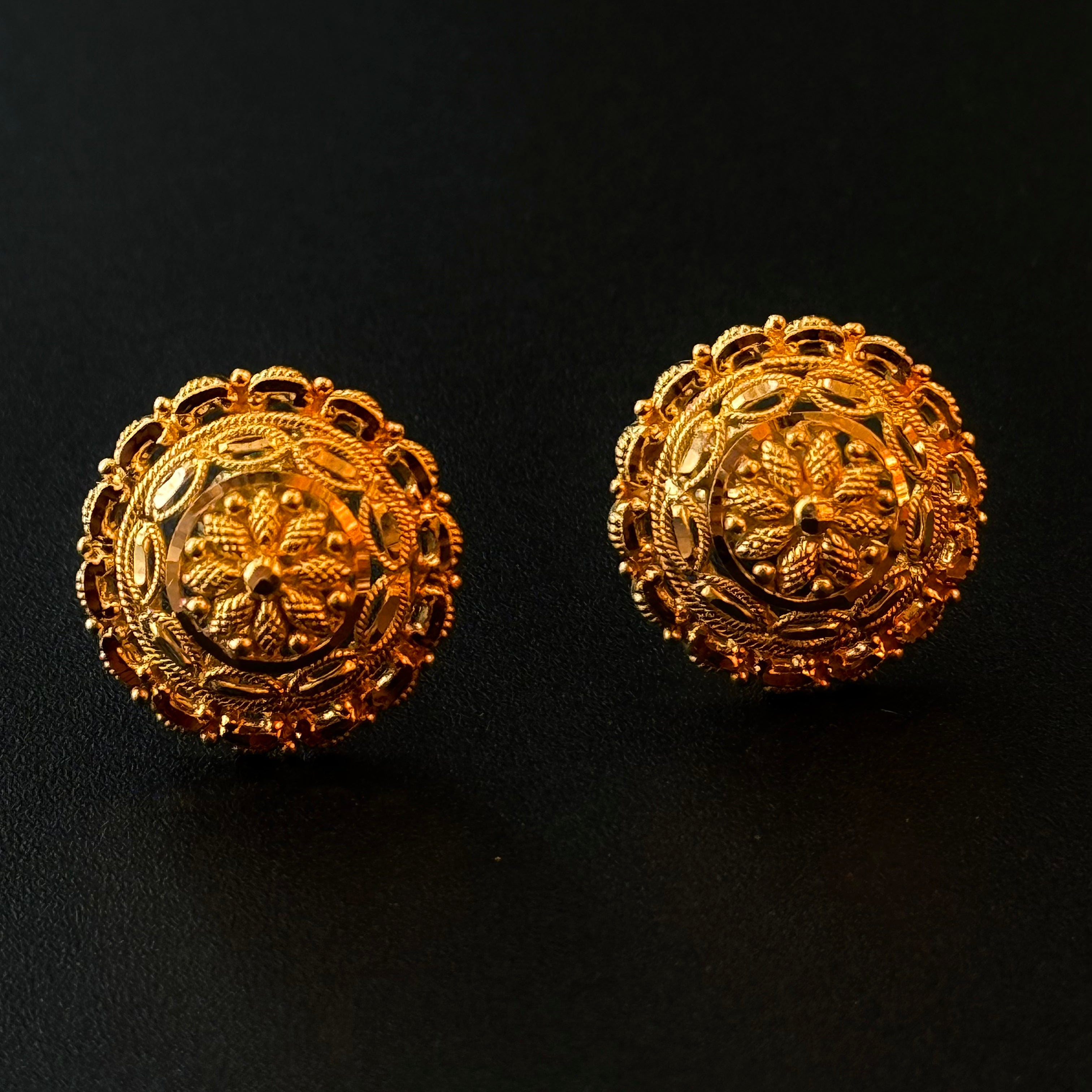 Pair of gold earrings on a black background