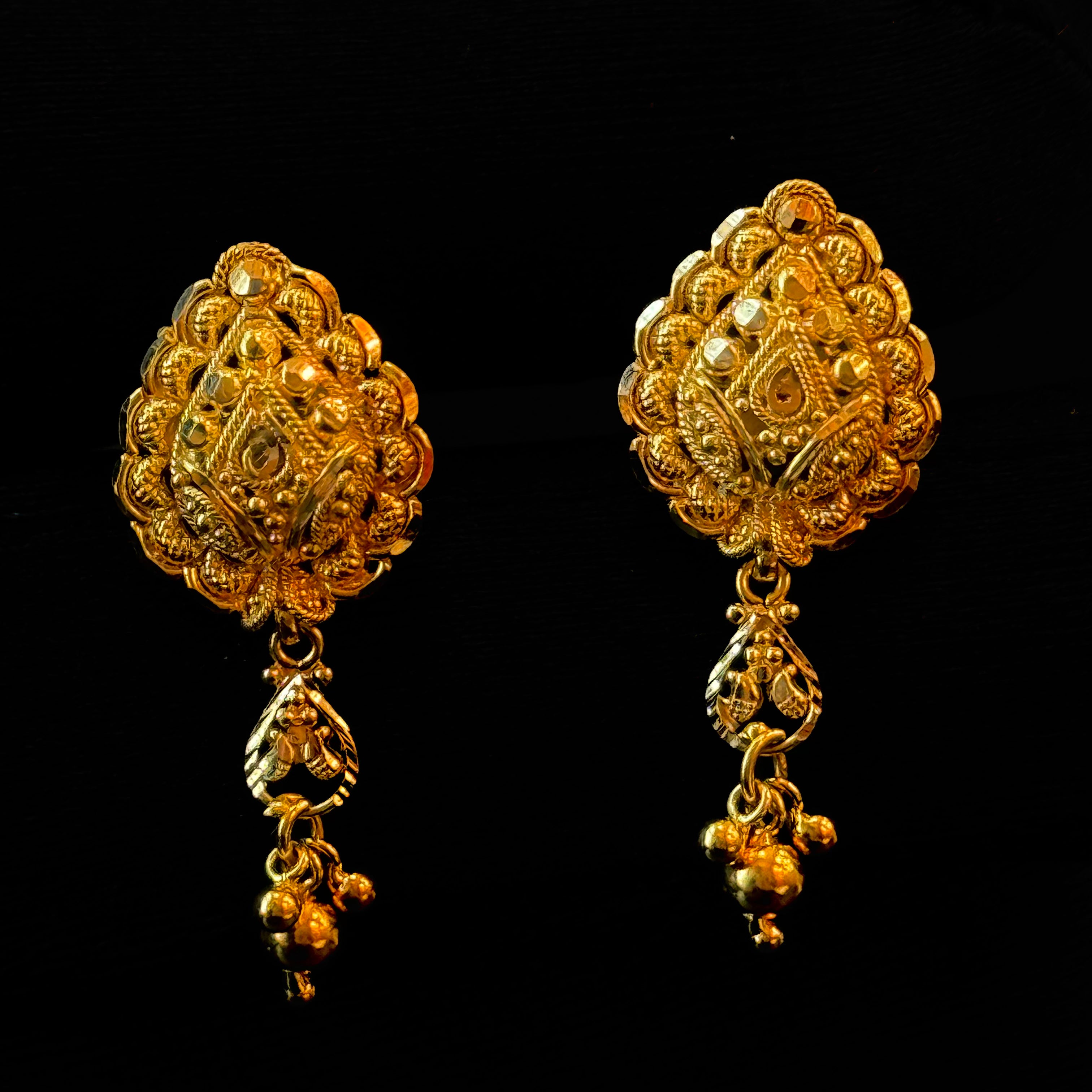 Pair of gold earrings on a black background
