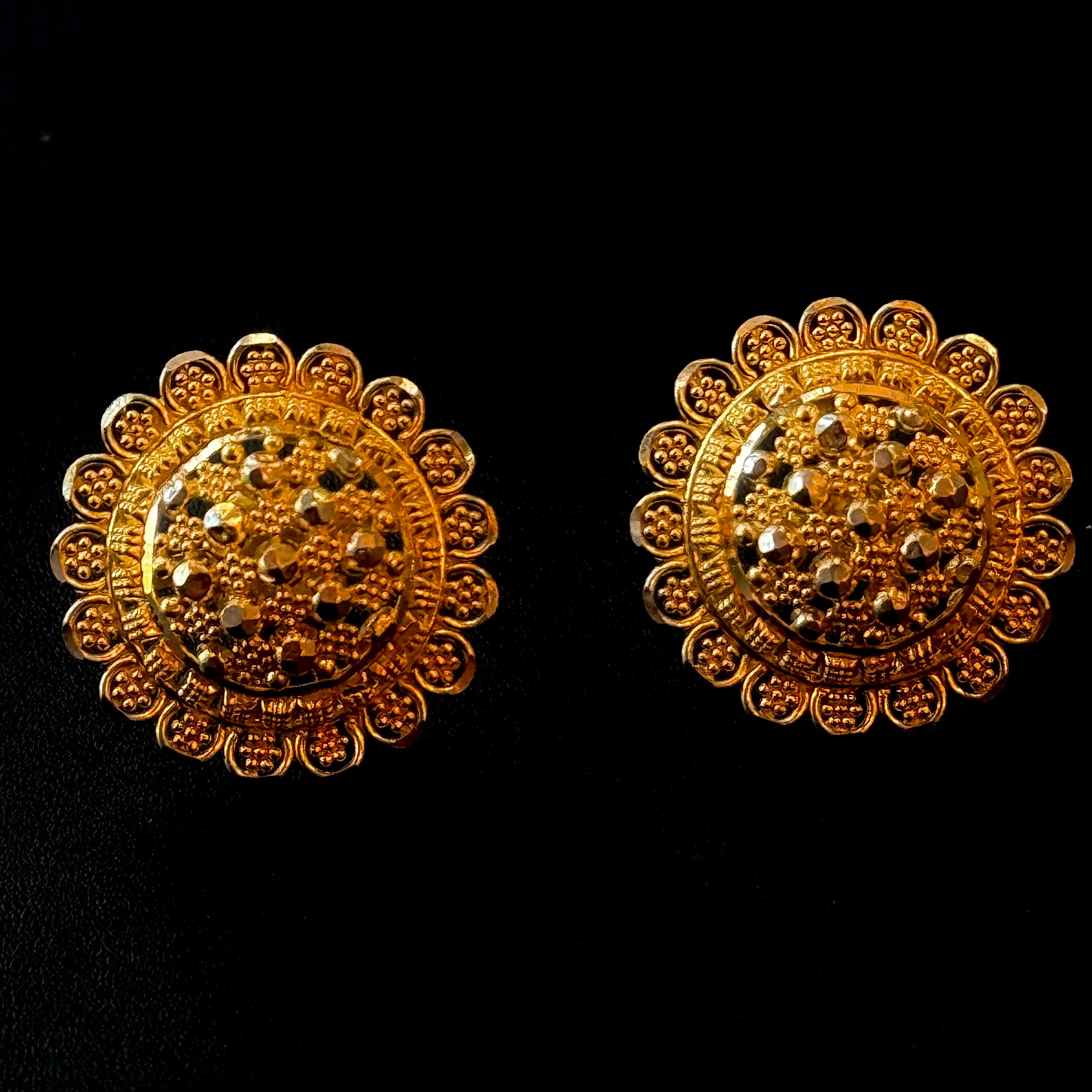 Pair of gold earrings on a black background