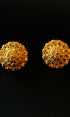 Pair of gold earrings on a black background
