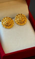 Gold earrings in a red and beige jewelry box