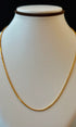 Gold necklace on a mannequin with a black background