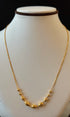 Gold necklace on a mannequin bust with a black background
