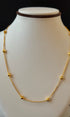 Gold necklace on a mannequin bust with a black background