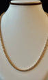 Gold necklace on a mannequin bust against a black background