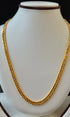 Gold chain necklace on a mannequin bust against a black background